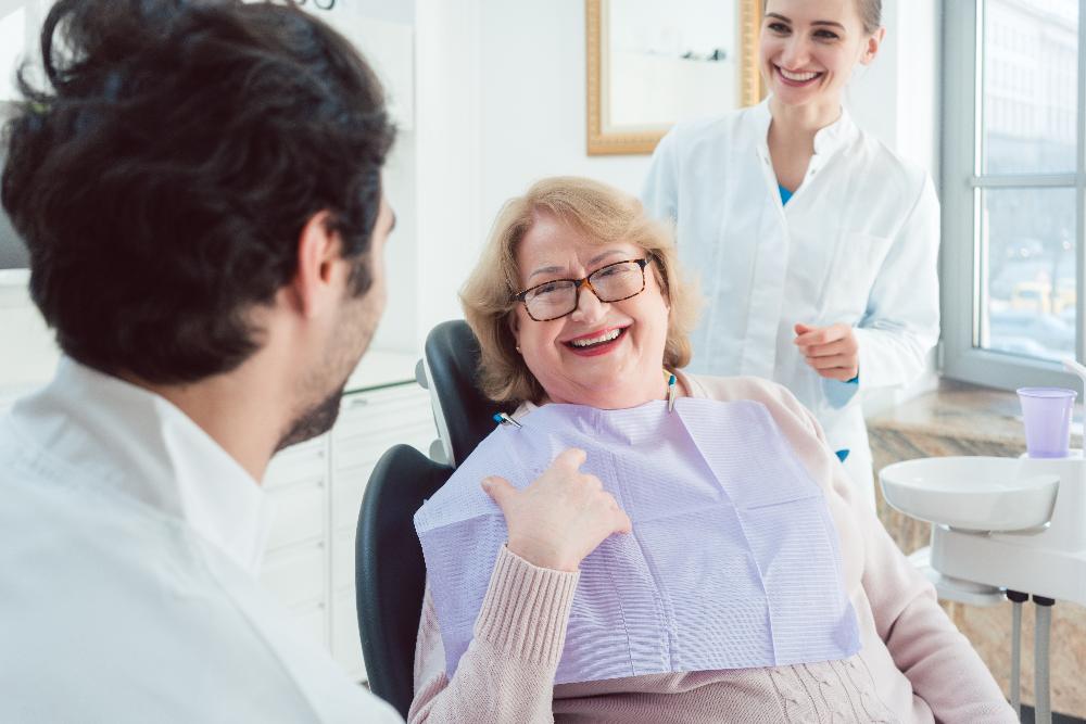 A woman laughing while speaking to her dentist