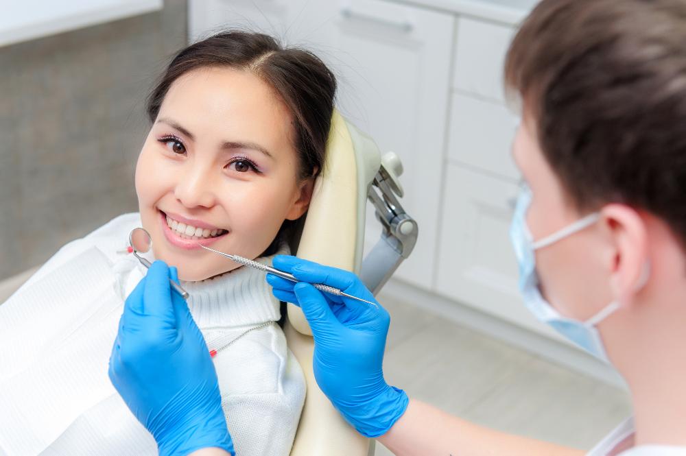A smiling woman getting a dental exam in Mitchell