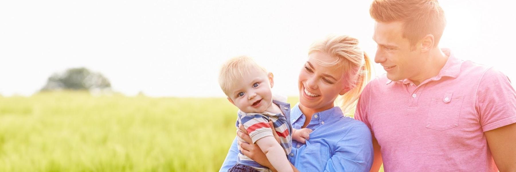 Parents and their baby smiling outside near Mitchell SD
