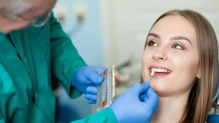 Dentist in Mitchell SD checking the teeth whitening shade of a patient